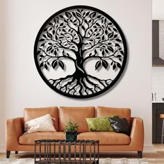 a living room with a couch, table and large metal tree wall art