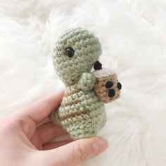 a hand holding a small crocheted stuffed animal