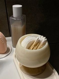 two soaps and a brush on a bathroom sink next to a bottle of lotion