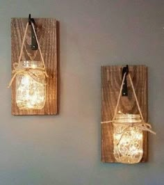 two mason jar lights are hanging on the wall next to each other with string wrapped around them