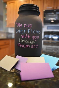 a black jar with writing on it sitting on top of a counter next to post - it notes