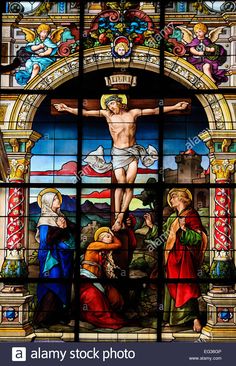 stained glass window depicting the crucifix with jesus on the cross and other people