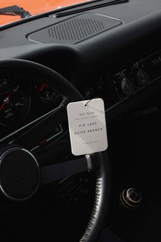 the steering wheel and dashboard of an old car with a sign on it that says, no leaf only