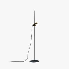 a black floor lamp with a wire attached to it's base and a white background