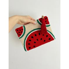 a hand holding a crocheted watermelon purse