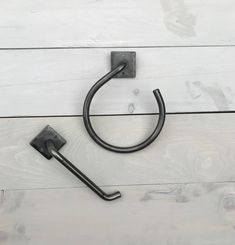 a metal hook on the side of a white wall