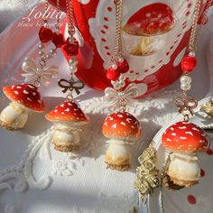 a table topped with red and white plates covered in jewelry next to a cupcake