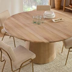 a round wooden table with four chairs around it