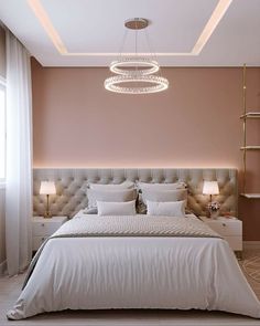 a large bed sitting under a chandelier in a bedroom