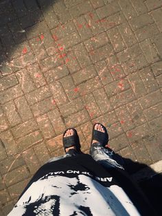 a person standing on the sidewalk with their feet in the air and red paint all over them