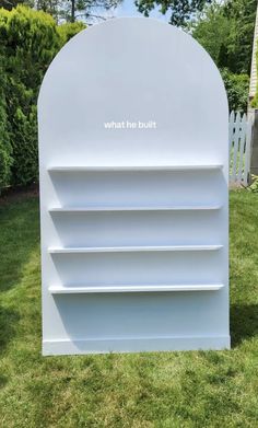 a white book shelf sitting in the grass