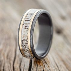 a wedding ring with antler wood and gold inlays on the inside of it