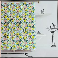 a shower curtain with flowers on it next to a sink