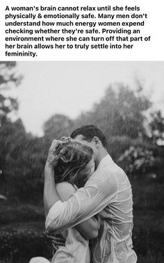 a man and woman sitting on the ground in the rain with their arms around each other