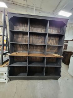 an empty bookcase in a warehouse with shelves and other items on the floor behind it