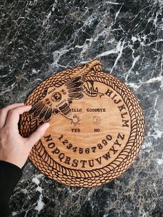 🌟 Welcome to the Mystical Realm 🌟 🌲 Handcrafted Wooden Ouija Board 🌲 🌠 Unveil the secrets of the spirit world with our exquisite, one-of-a-kind wooden Ouija board. This enchanting piece of art is more than just a game; it's a portal to the unknown, a conversation with the other side. Each board is lovingly crafted by skilled artisans, making it a remarkable addition to your collection of mystical tools or a captivating statement piece for your home decor. 🔮 Key Features 🔮 ✨ Crafted from premium, sustainably sourced beech wood, our Ouija board boasts unparalleled craftsmanship and durability. ✨ Unique, intricate designs and hand-carved letters and symbols make every board a work of art. ✨ Smooth, velvet-lined planchette for an effortless glide across the board's surface. ✨ A portable Wiji Board, Ouija Board Art, Diy Ouija Board, Ouji Board, Rustic Table Numbers, To The Unknown, Spirit Communication, Deer Wall Art, Spirit Board