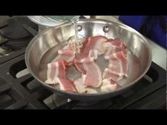 bacon being cooked in a pan on the stove with water pouring from a pitcher into it