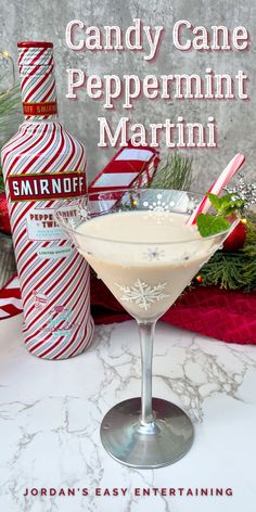 candy cane peppermint martini in a coupe glass on a table with christmas decorations