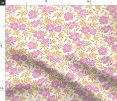 a white and pink flowered fabric with yellow leaves on it, next to a ruler