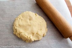 a cookie dough on a baking sheet next to a rolling pin