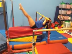 a person on a trampoline in a room with many other toys and equipment