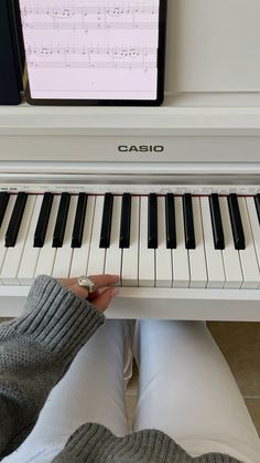 someone is playing the piano with their feet on the ground and holding it up in front of them