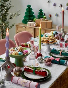 a table set for christmas dinner with plates and candles