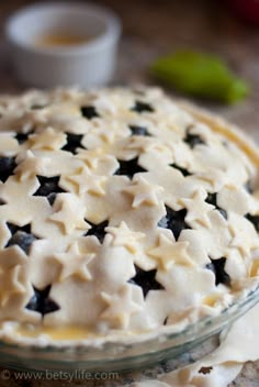 an uncooked pie with black and white stars on it sitting on a table