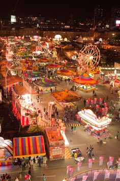 an aerial view of a carnival at night with many rides and fairgrounds in the background