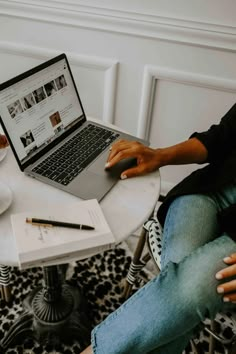 a person sitting at a table with a laptop on their lap and coffee in front of them