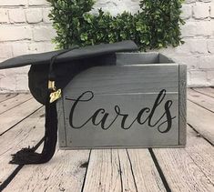 a wooden box with a graduation cap on it that says cards in cursive writing