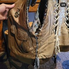 someone is trying to fix the back of an old pair of boots with laces on them