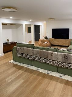 an empty living room with couches and a flat screen tv