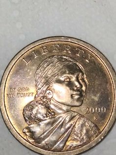 an image of a coin with a woman holding a baby on it's back