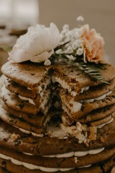 a stack of cookies with white frosting and flowers on top are stacked up together