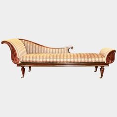 an antique style chaise lounge with striped upholstered fabric and wood trimmings