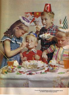 three children eating cake at a table with birthday hats on their heads and one child wearing a party hat