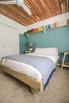 a bed sitting under a wooden ceiling in a bedroom