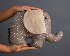 a person holding an elephant stuffed animal in their hands