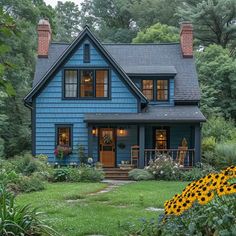 a blue house with flowers in front of it