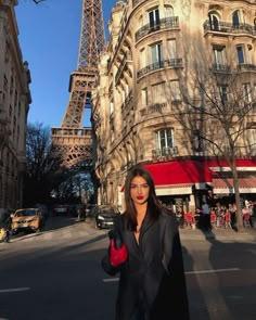 a woman standing in front of the eiffel tower with her hand on her hip