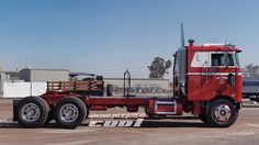 a red semi truck parked in a parking lot