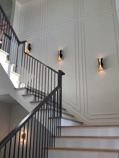 two lights are on the wall above some stairs