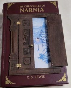 the book is opened to show an image of a snowy scene and its name on it