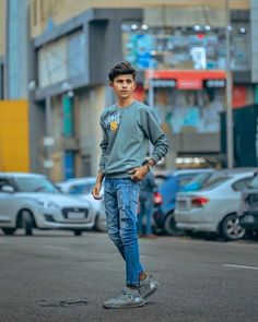 a young man is standing on the street