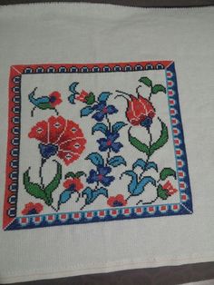 an embroidered square with flowers on it