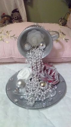 a decorative tray with beads and flowers on it sitting on top of a white bed