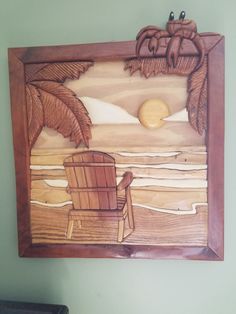 a wooden wall hanging with a chair and palm tree