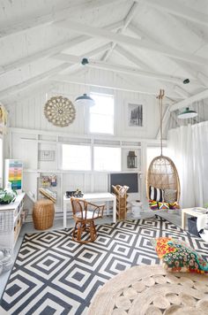 a living room with white walls and black and white rugs on top of the floor