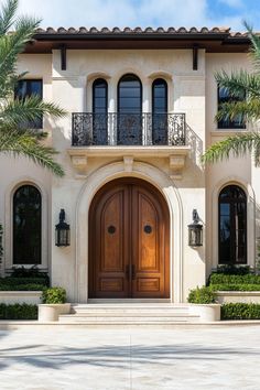 the front entrance to a large home with palm trees